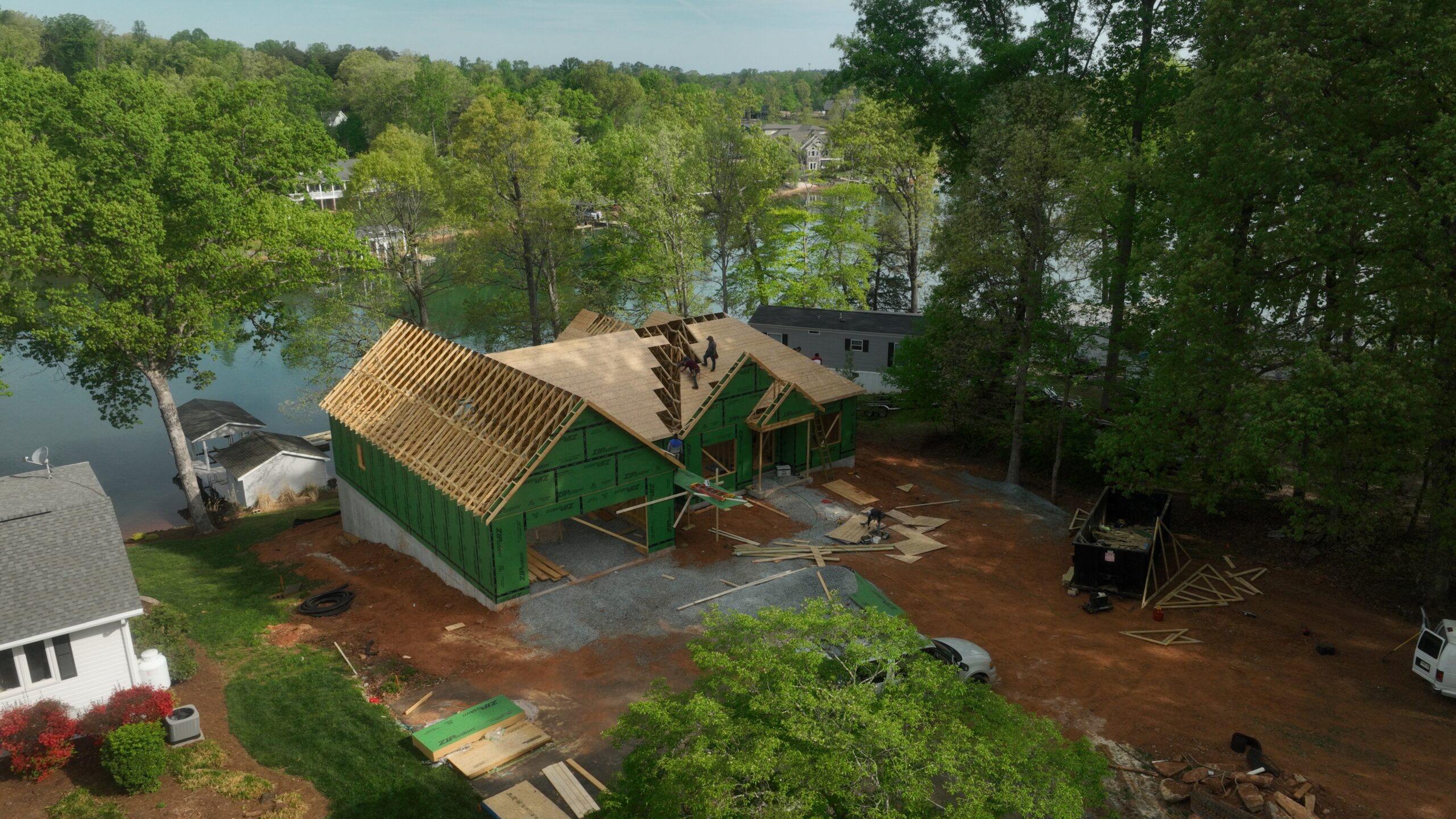 A custom home build with roof trusses being installed and ZIP System sheathing on the walls
