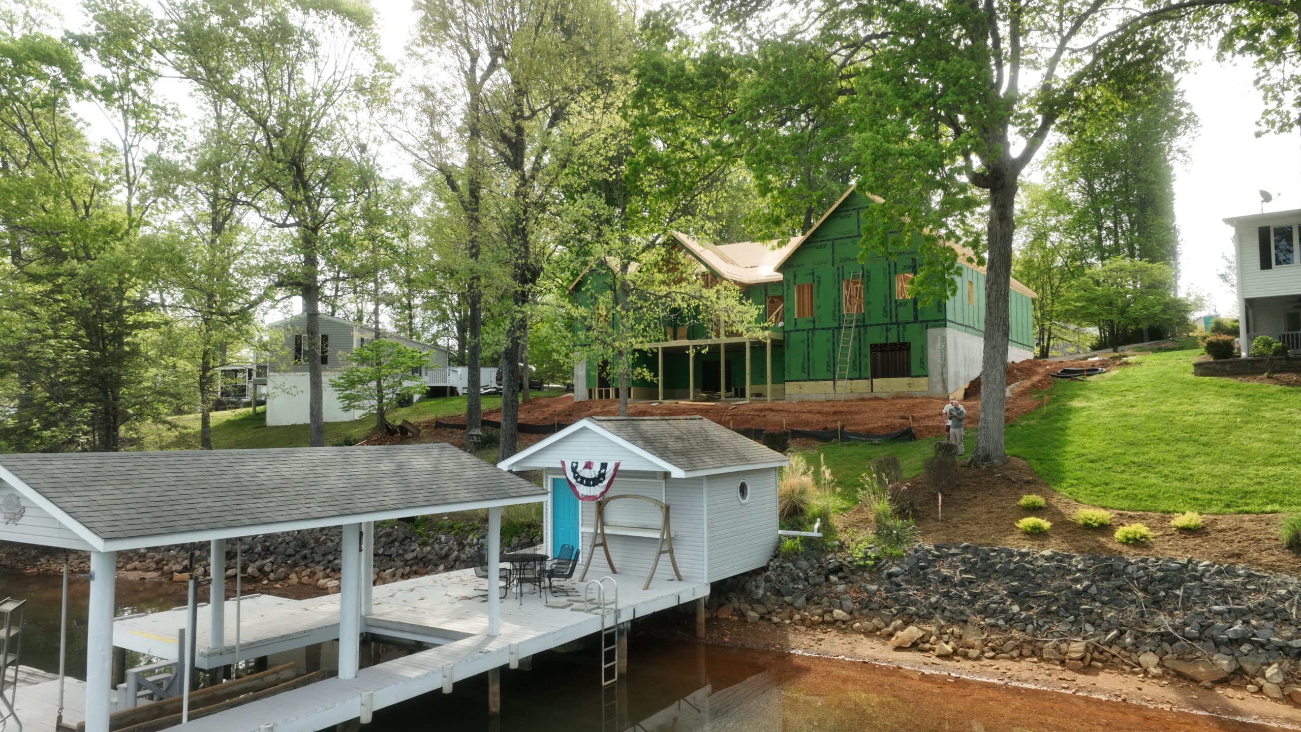 Top-down aerial view of a custom home build with roof framing in progress